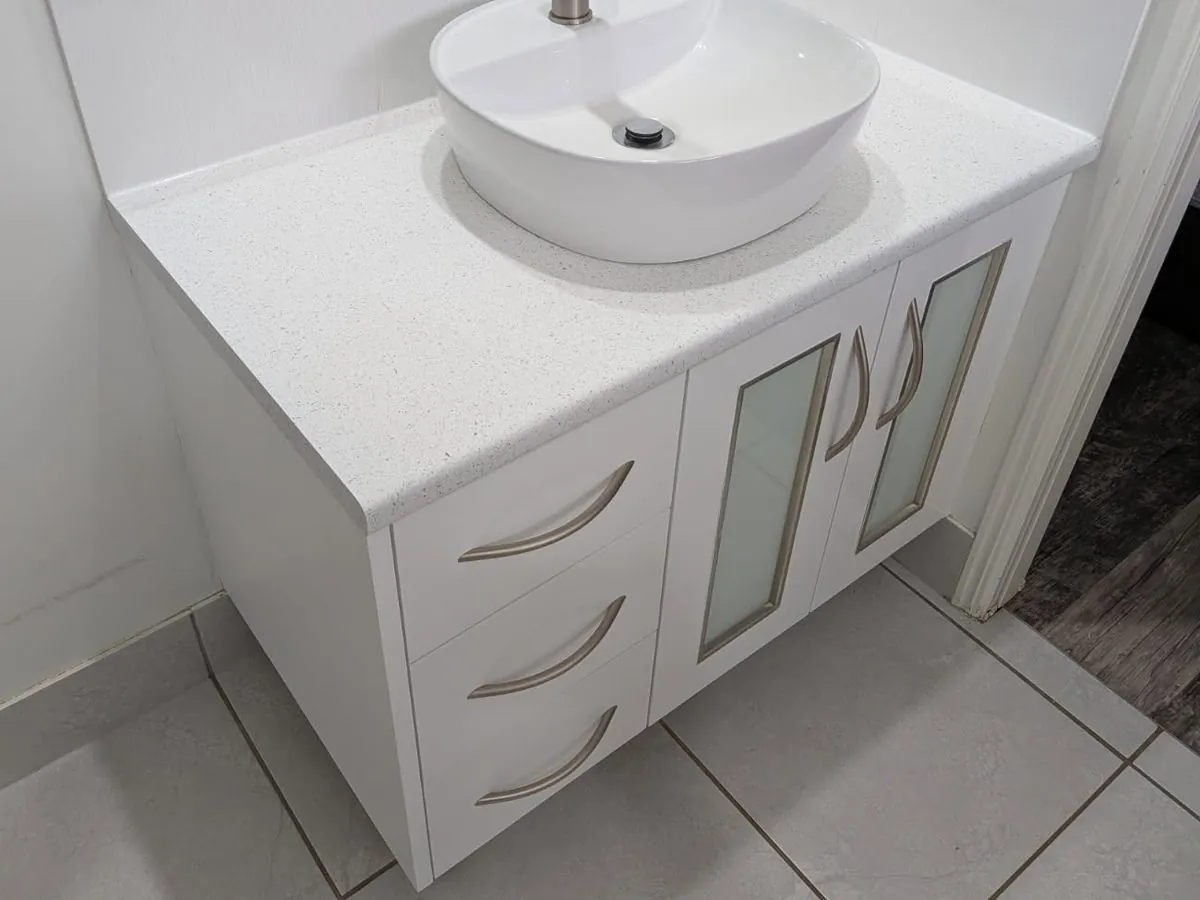 The same vanity after resurfacing, in white with a white stone-look benchtop